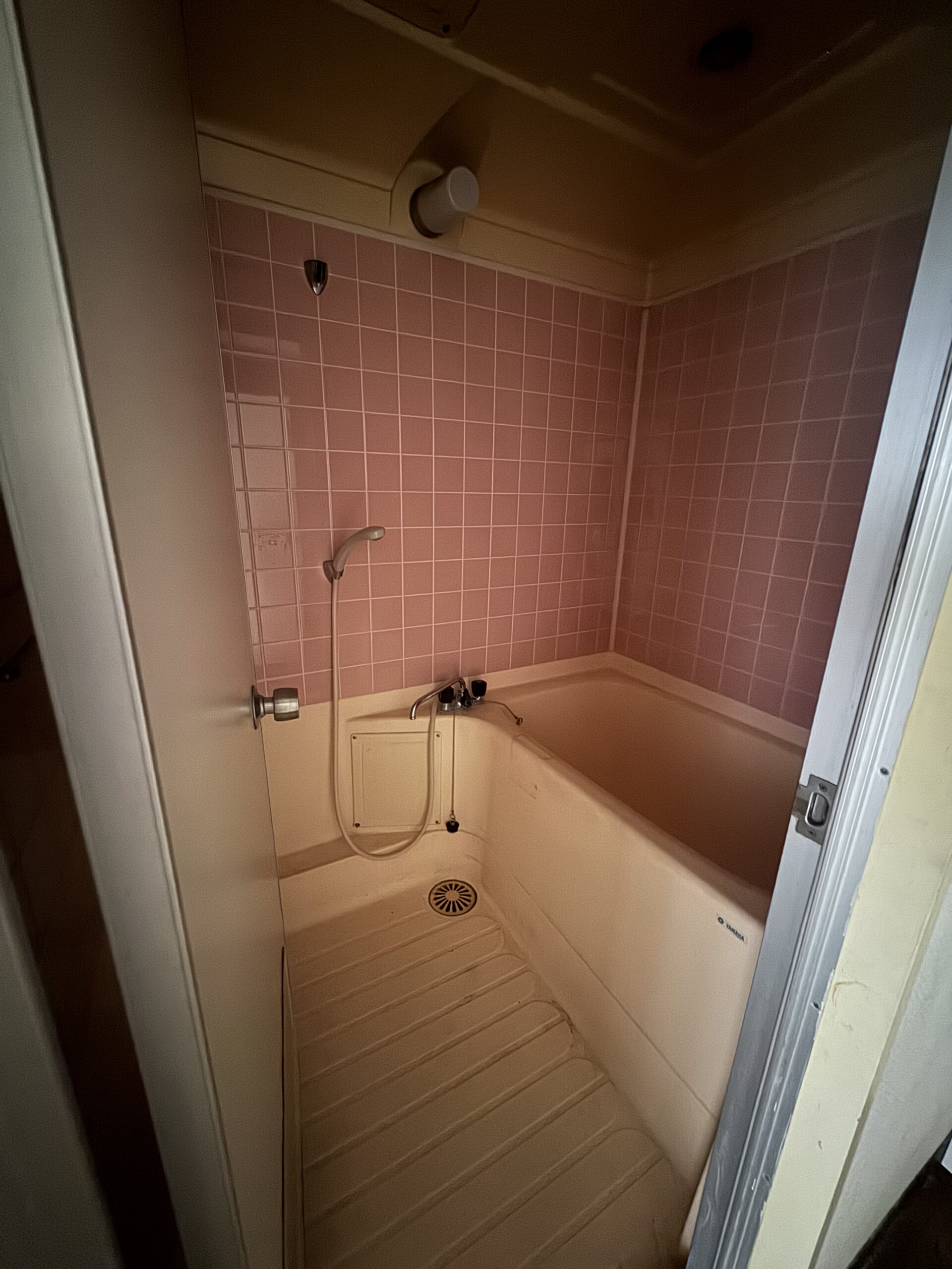 天井の化粧梁と、格子入りのドアが印象的なリビング。可愛らしさのなかに、キッチンのグレータイルで上品さもプラスした内装に。