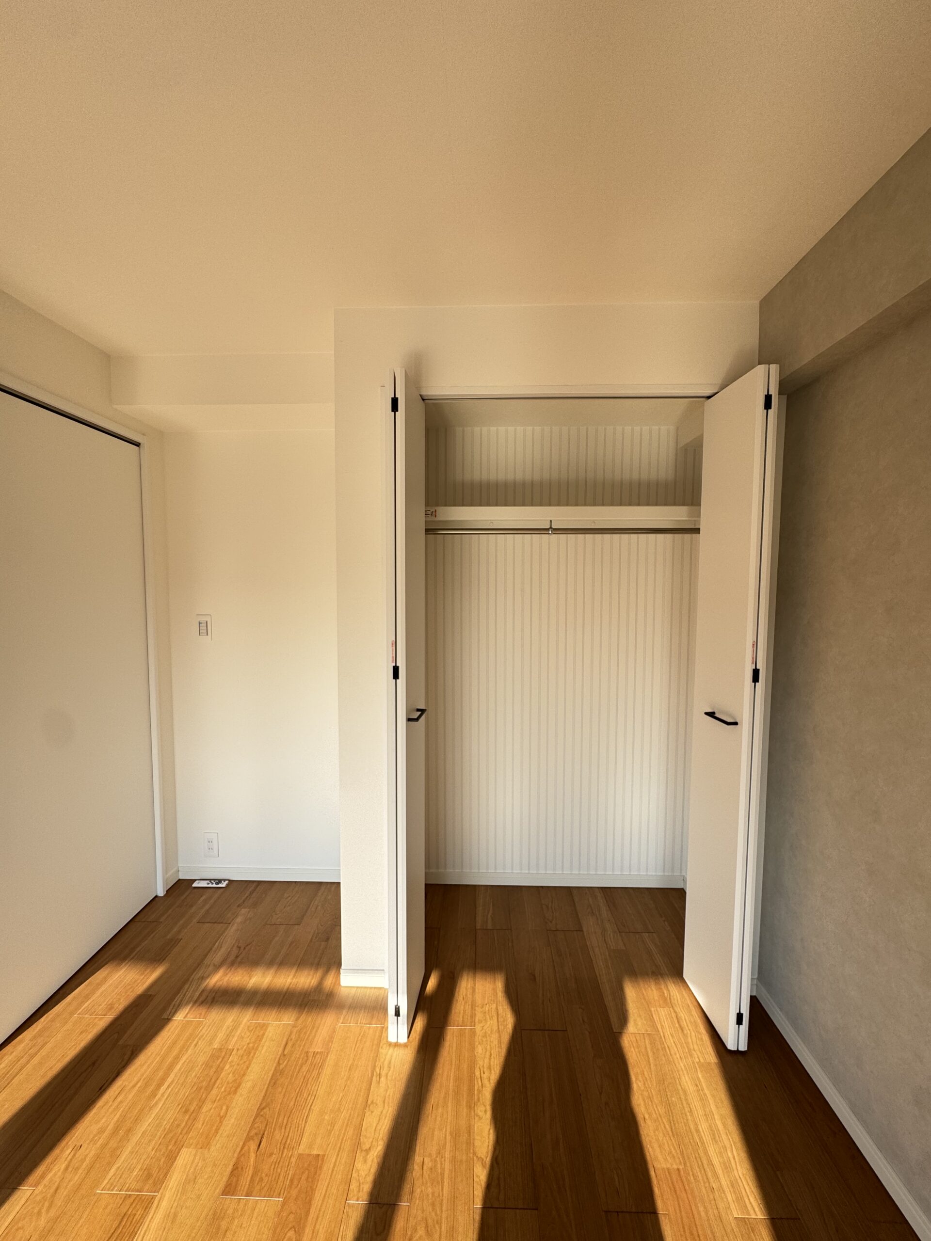 天井の化粧梁と、格子入りのドアが印象的なリビング。可愛らしさのなかに、キッチンのグレータイルで上品さもプラスした内装に。