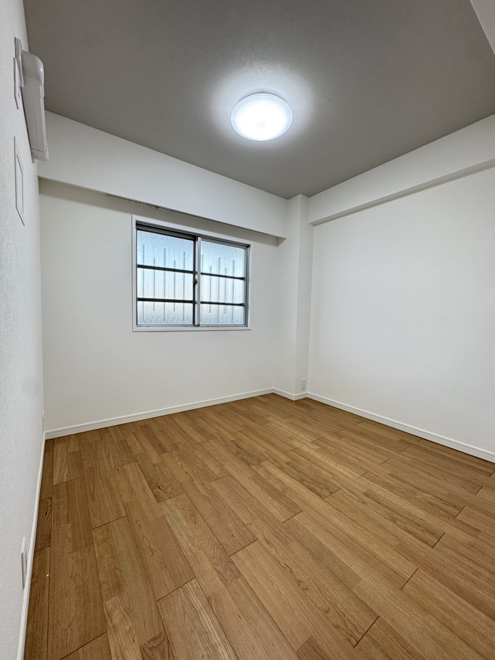 天井の化粧梁と、格子入りのドアが印象的なリビング。可愛らしさのなかに、キッチンのグレータイルで上品さもプラスした内装に。