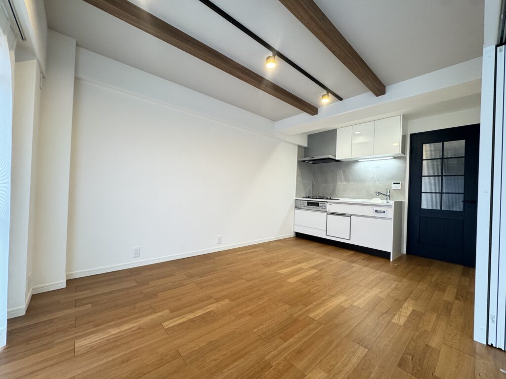 天井の化粧梁と、格子入りのドアが印象的なリビング。可愛らしさのなかに、キッチンのグレータイルで上品さもプラスした内装に。
